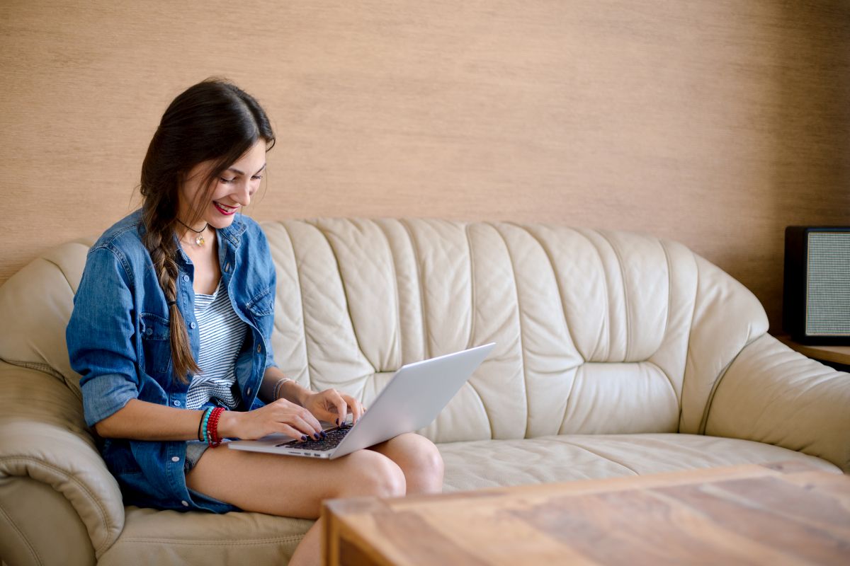 kobieta z laptopem na skórzanej sofie